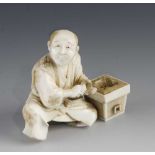 A 3" ivory okimono of a man with trowel at work