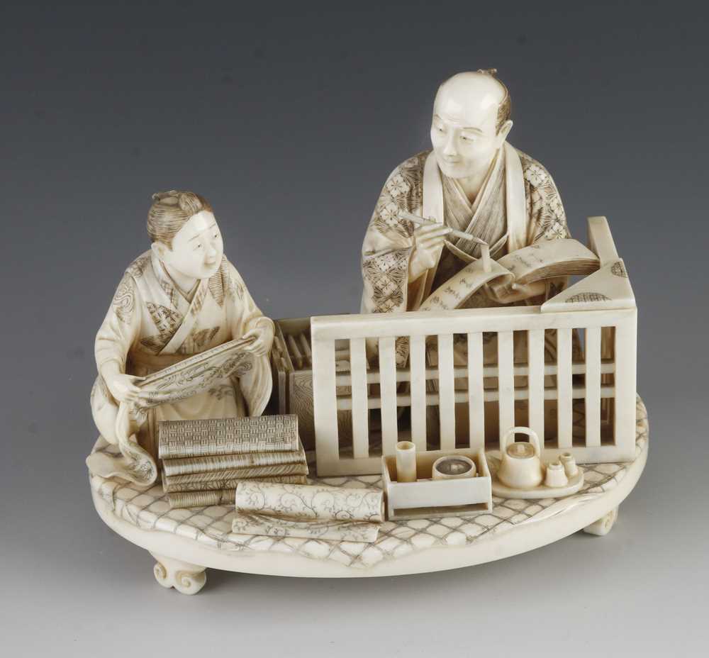 A fine ivory okimono of a draper taking notes as his apprentice measures the cloth 5" x 4"