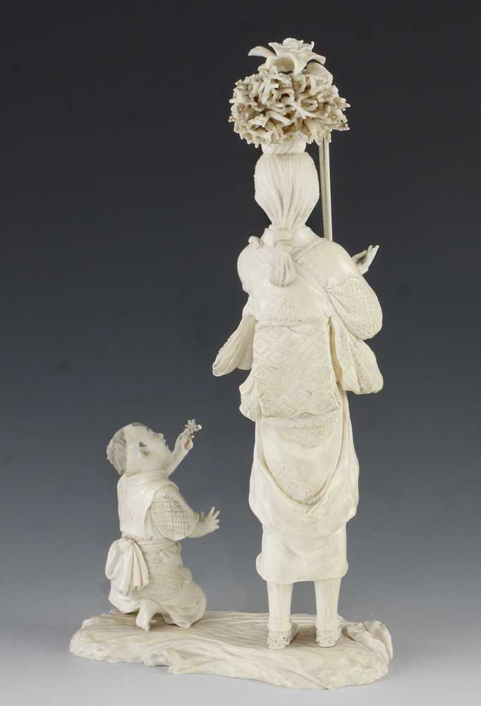 A 9" ivory okimono of a mother carrying carrying a bundle of sticks being handed a butterfly - Image 3 of 5