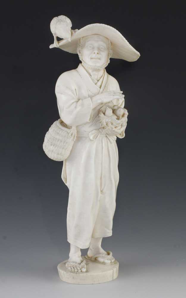 A 10" ivory okimono of a man carrying a nest with two fledglings and the concerned mother bird on