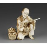 A 4" ivory okimono of a man weighing eggs signed