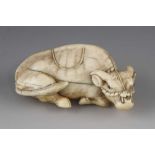 A 2 1/2" ivory okimono of a recumbent ox