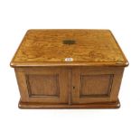 A fine quality cutlery cupboard burr oak with three drawers behind a pair of cupboard doors with