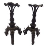 A pair of Chinese bronze candlesticks, 19th century, each with a baluster stem and dragon mask