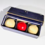 A boxed set of three ivory billiard balls, circa 1900-1920, each diameter 5cm.