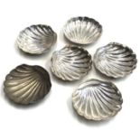 A set of six Egyptian silver scallop shaped bon bon dishes, each with three shell shaped feet,