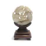 A Chinese circular jade carving of a dragon and rat, 17th century, on later hardwood stand, diameter