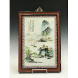 A Chinese famille rose porcelain plaque, depicting a mountainous river scene, with calligraphy and