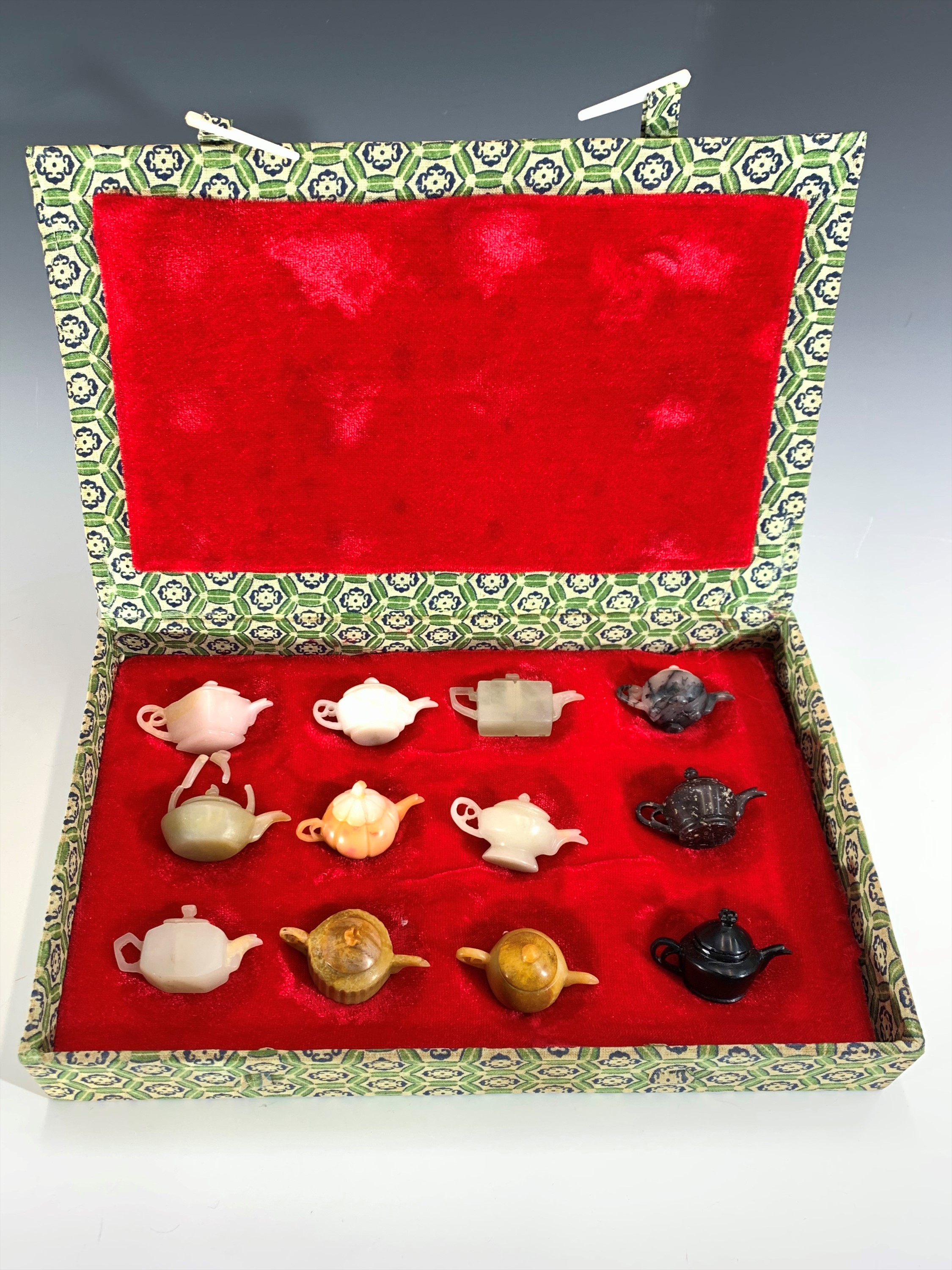 A set of Chinese miniature hardstone models of teapots, boxed.