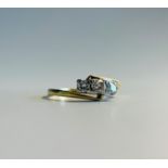 An 18ct gold three diamond crossover ring.
