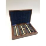 A walnut and blue velvet lined cased set of early 20th century opticians opthalmic lenses to include