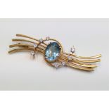 A 1950's 18ct gold brooch with central aquamarine of about 3cts from this spins two lines of