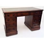 A Victorian mahogany pedestal desk, the green leather inset top above an arrangement of nine