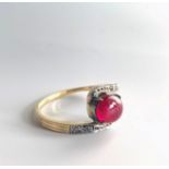 A cabochon ruby and diamond crossover ring.