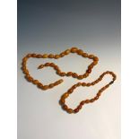 A butterscotch amber necklace the largest bead 19mm 34.5gm together with a small amber necklace 11.