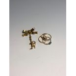 Three gold rings, a gold bow clip brooch and a gold charm 7.9gm