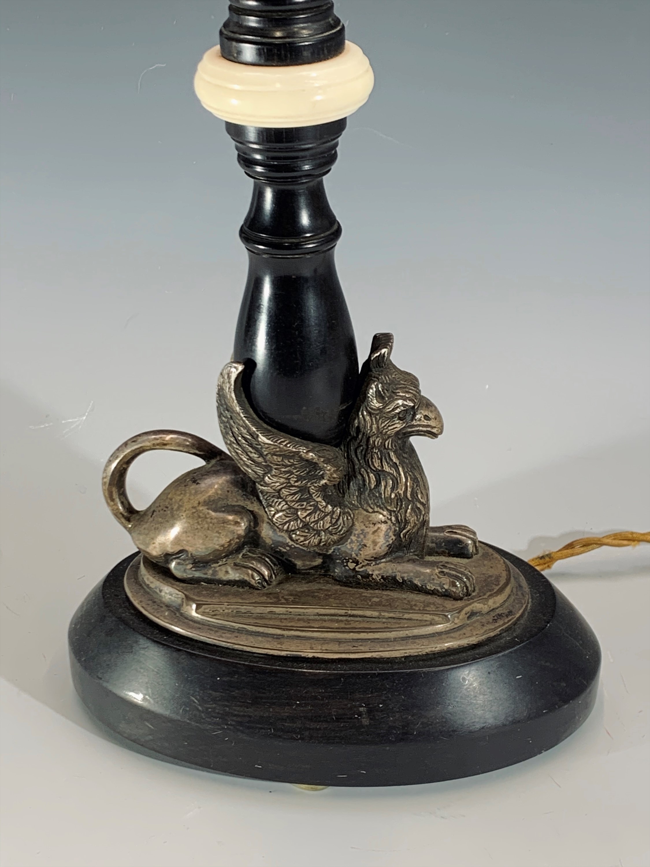 An early 20th century ebonised wood and ivory table lamp, the plated base in the form of a recumbent - Image 2 of 3