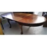 A mahogany extending dining table, circa 1900, with two extra leaves, with cabriole legs and ball