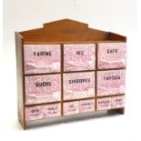 An early 20th century French spice cabinet, the pink and white gilded ceramic drawers fitted in a