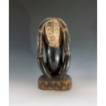 A Papua New Guinea ancestral carved wood figure, with inset cowrie shell eyes. Height 50.5cm.