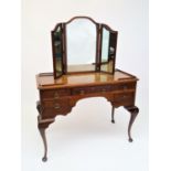 A walnut dressing table, with triple mirror back and fitted an arrangement of five kneehole