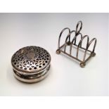 An Edwardian pierced silver potpourri box Chester 1907 2.3oz together with a silver toast rack 2.