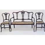 A late Victorian mahogany three piece salon suite, with carved top rails and pierced splats, on