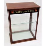 An Edwardian mahogany counter top shop display cabinet, by Carr of Carlisle, with two glass shelves,