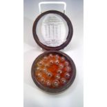 A set of spirit beads, cased in a circular mahogany box.