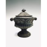 An early 20th century cast iron lidded urn.Height 20cm.