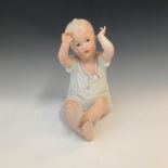 An early 20th century bisque piano doll, modelled with raised arms. Height 20cm.Condition report: