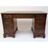 A mahogany twin pedestal desk of Georgian style, 20th century, with an arrangement of nine drawers