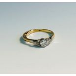 An 18ct gold and platinum ring set a diamond of approximately 0.25ct each shoulder with a trio of