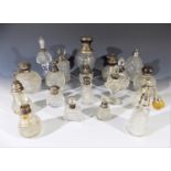 A collection of glass scent bottles and atomisers, many with hallmarked silver lids or collars.