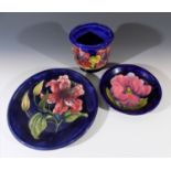 A Moorcroft 'Bermuda Lily' pattern plate, 25.5cm, together with a 'Hibiscus' pattern jardinière