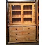 A pine bookcase, with a pair of glazed doors, the lower part with two short and two long drawers,