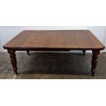 A late Victorian mahogany extending dining table, with turned tapering legs, two leaves and a