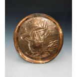 A Newlyn copper charger of circular form, repousse decorated with a galleon, stamped NEWLYN verso.