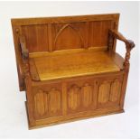 An oak monks bench, with hinged seat and triple carved linen fold base, width 94cm.