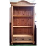 A late 19th century Continental pine open bookcase, the arched top above reeded columns with three