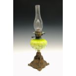An early 20th century oil lamp, the green glass reservoir with gilded decoration. Height 34cm (