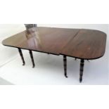 A mahogany extending dining table, early 19th century, with two extra leaves, with turned tapering