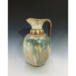 A large studio pottery stoneware ewer, with incised geometric band to the neck, green and blue