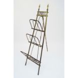 An Edwardian folding brass magazine rack, with easel support, height 130cm. (Qty: 1)