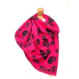 A bright pink Alexander McQueen wool, silk and cashmere scarf with iconic black skull design, with