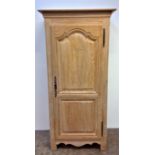 A limed oak single armoire by Christian Pingeon with an arched panelled door, height 192cm, width