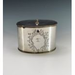 A silver plated tea caddy of oval form with chased decoration and engraved crest. Height 9cm,