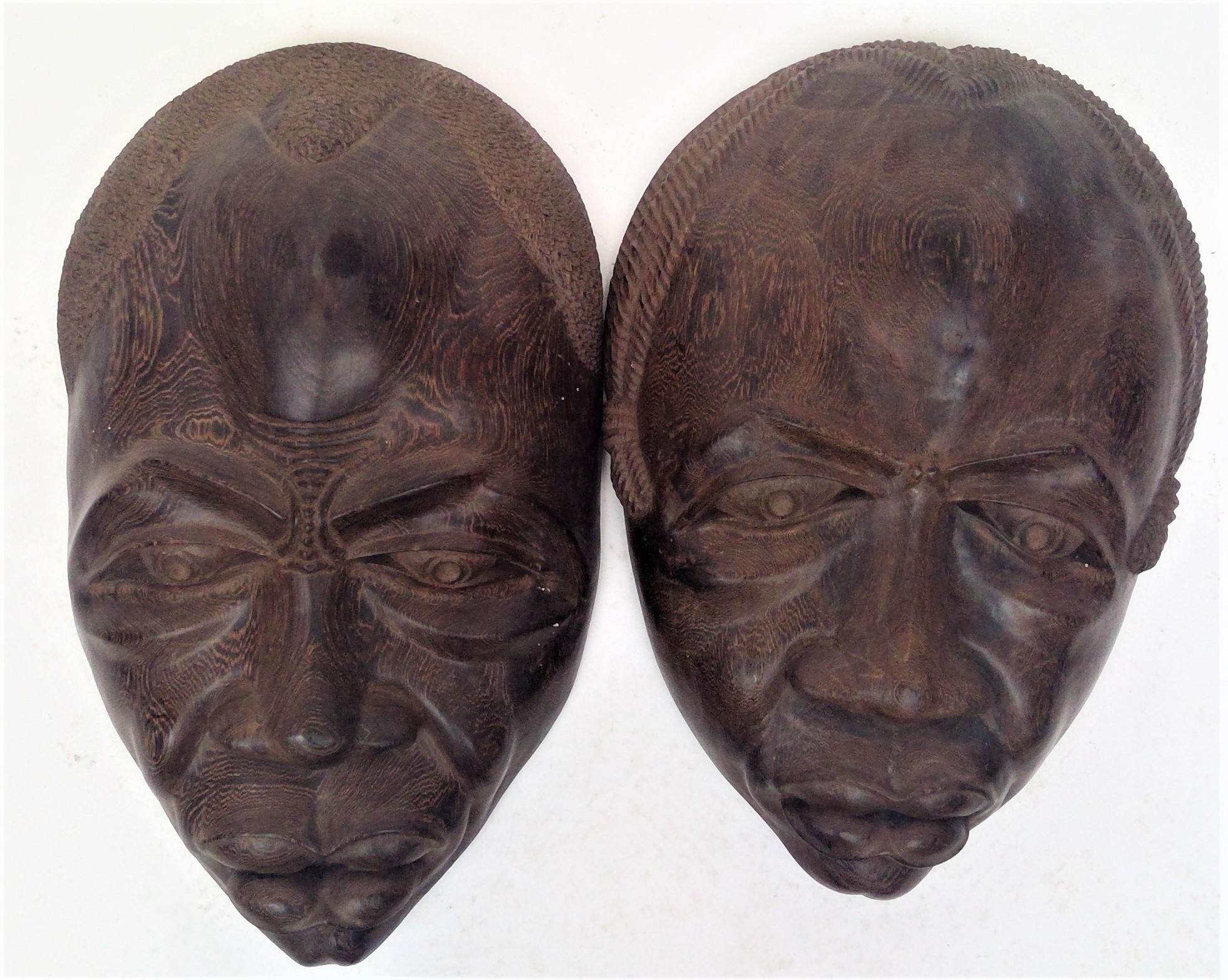 A pair of large figured hardwood tribal masks, with well detailed facial detail. Height 58cm.