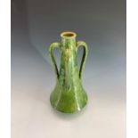 An Arts and Crafts period art pottery green glazed four handled vase. Height 44cm.Condition