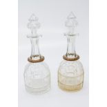 A pair of Victorian cut glass decanters and stoppers, each with unusual copper mounted ring.